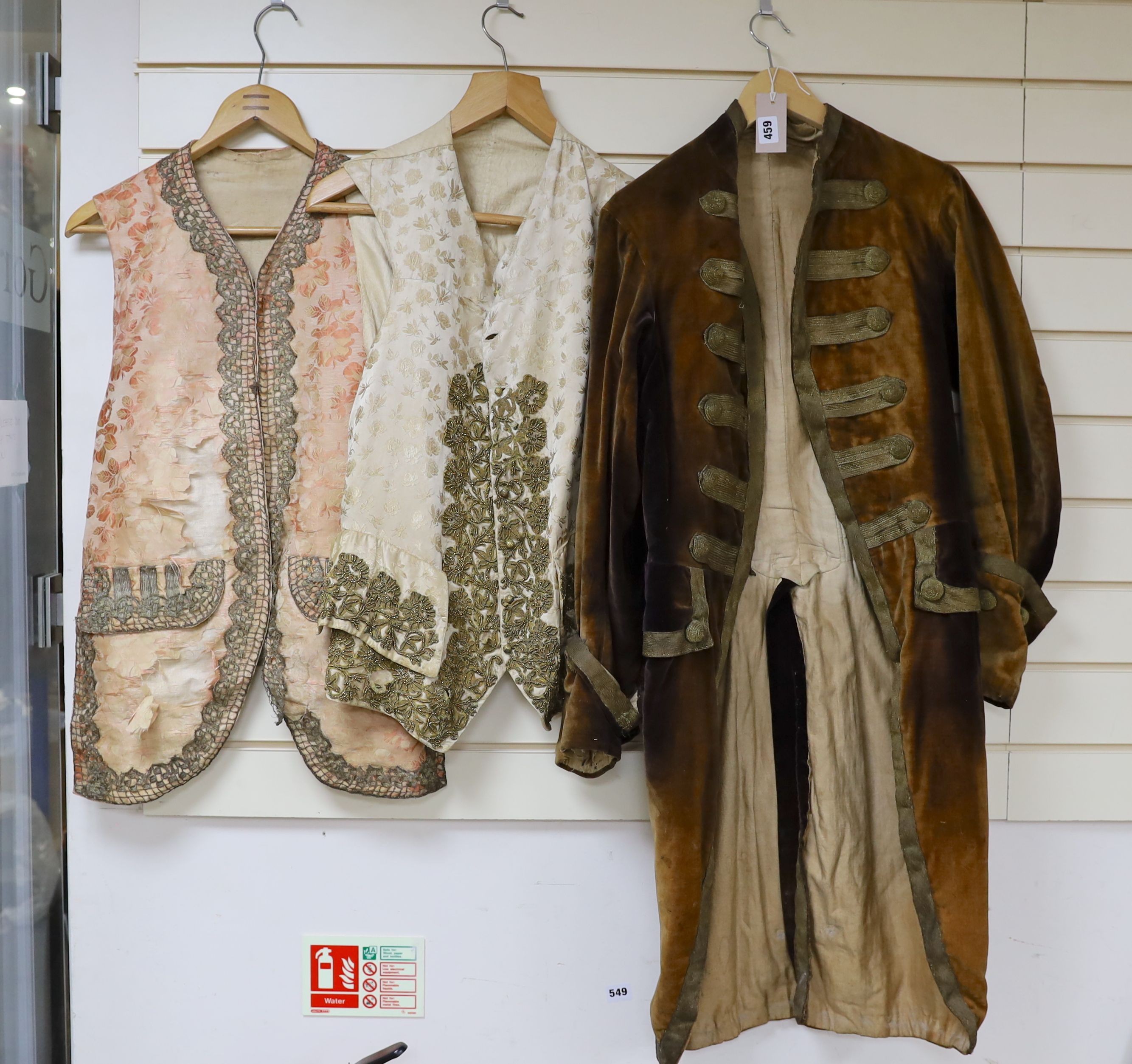 A Georgian gents cream damask waistcoat, a similar waistcoat with beading applied later and a velvet and gold braided tailcoat
